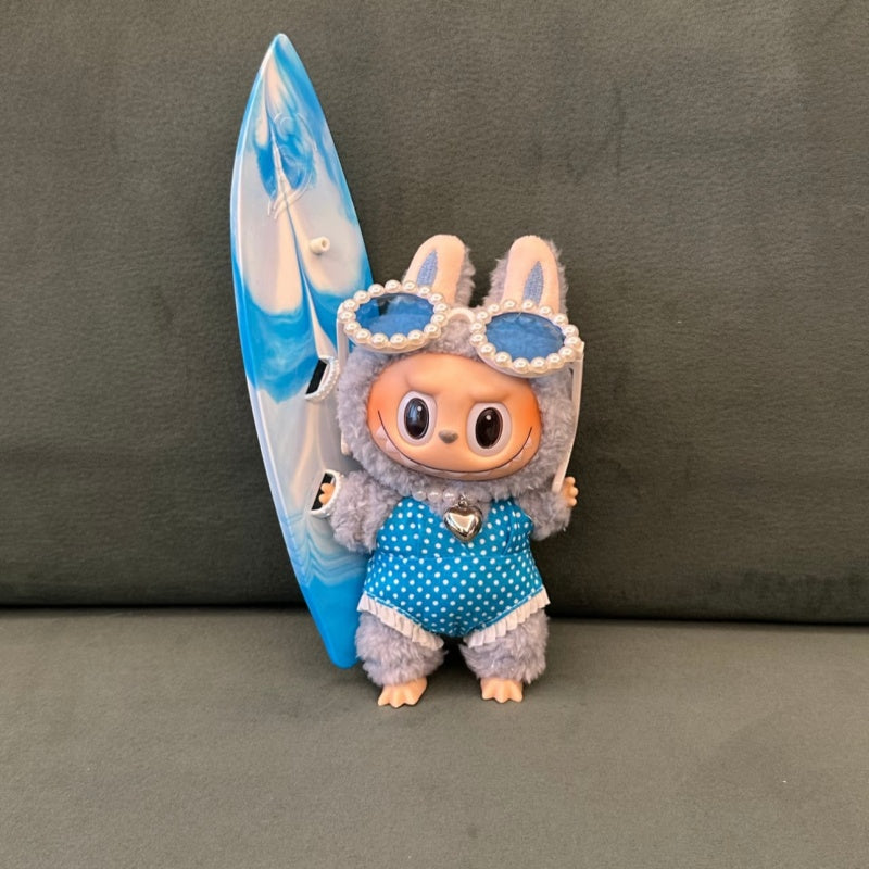 Labubu doll wearing blue surfing outfit with matching surfboard and accessories. Outfit fits all Labubu dolls, doll sold separately.